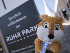 Kids Week Maskottchen vor Ruhrpark Schild