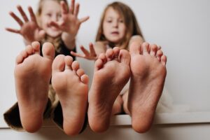 Gesunde Kinderfüße: Zwei Kinder mit Füßen im Vordergrund