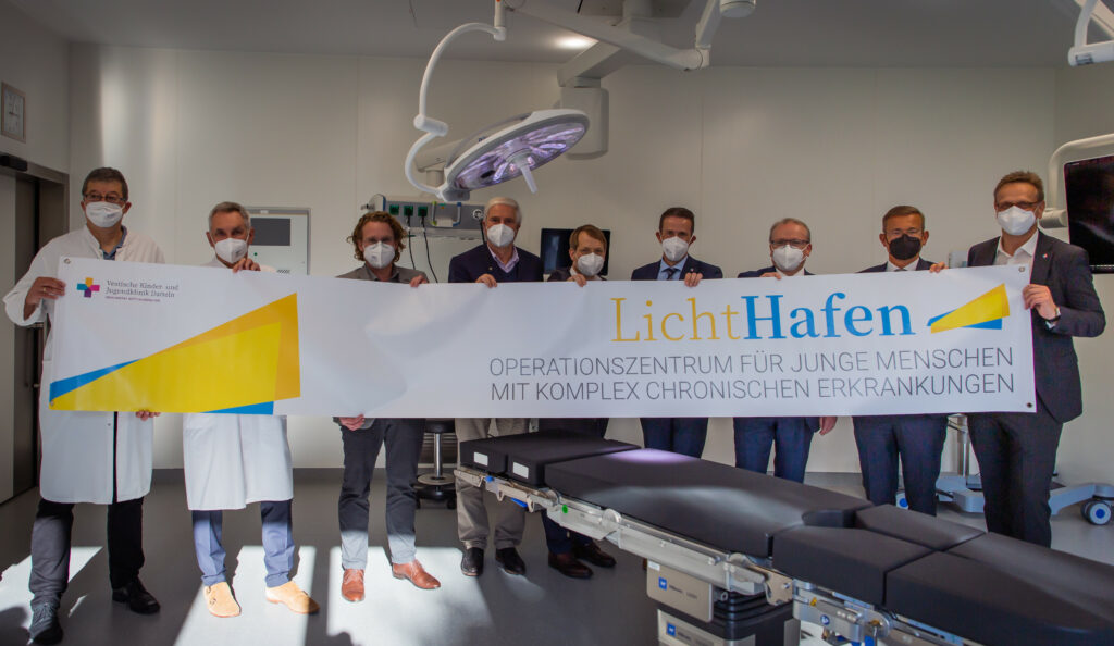 LichtHafen: Verantwortliche halten Banner des LichtHafens in der Hand in einem OP Saal