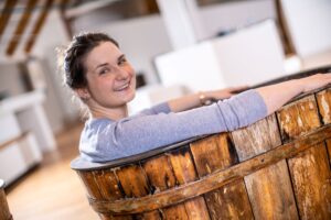Westfälische Salzwelten: Frau sitzt in alter Holzwanne