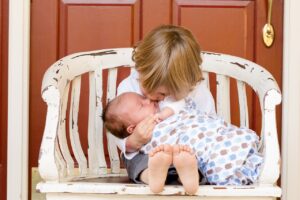 Tragetipps: Großes Geschwisterkind mit Baby auf dem Schoß