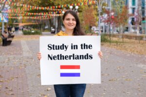 Auslandsstudium in den Niederlanden: Lächelnde Frau hält ein Plakat mit Text hoch