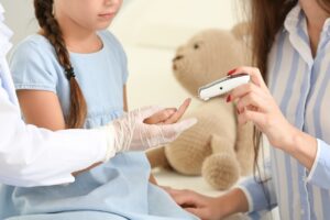 Diabetes bei Kindern. Mädchen bekommt Blut im Finger abgenommen