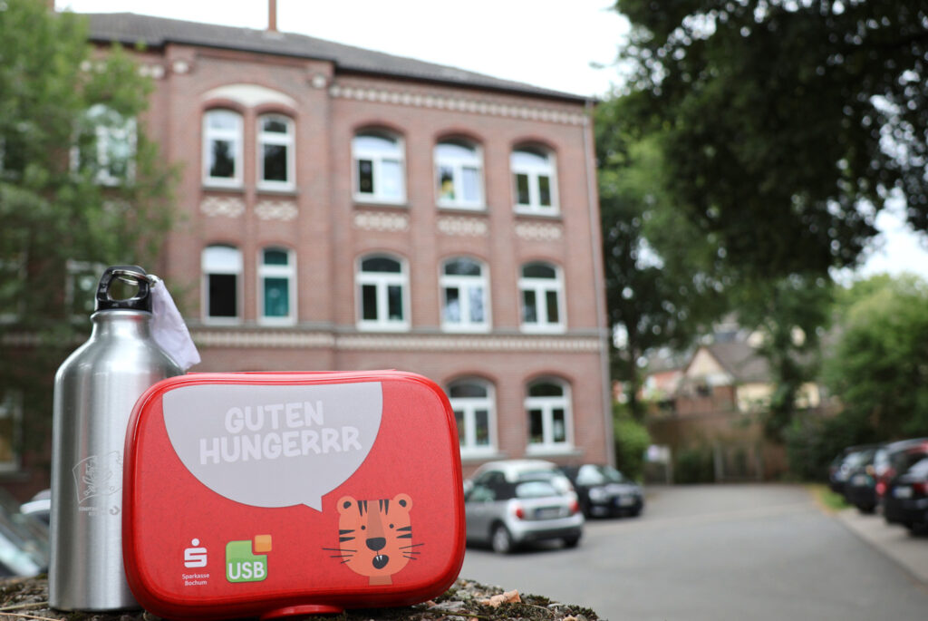 Brotdosen und Trinkflaschen des USB Bochum, der Stadtwerke Bochum und der Sparkasse Bochum